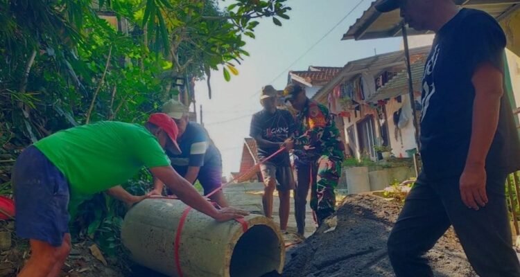 Babinsa Kedungkandang Perkuat Silaturahmi Lewat Gotong Royong Pembuatan Drainase