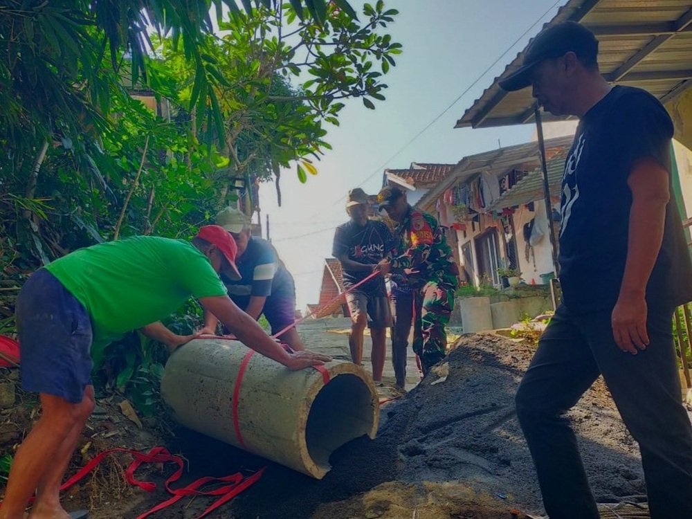 Babinsa Kedungkandang Perkuat Silaturahmi Lewat Gotong Royong Pembuatan Drainase
