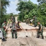 Anggota Koramil Sukun Gotong Royong Rakit Rangka Pagar Jembatan Perintis Garuda