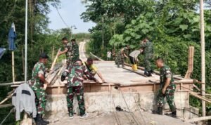 Anggota Koramil Sukun Gotong Royong Rakit Rangka Pagar Jembatan Perintis Garuda