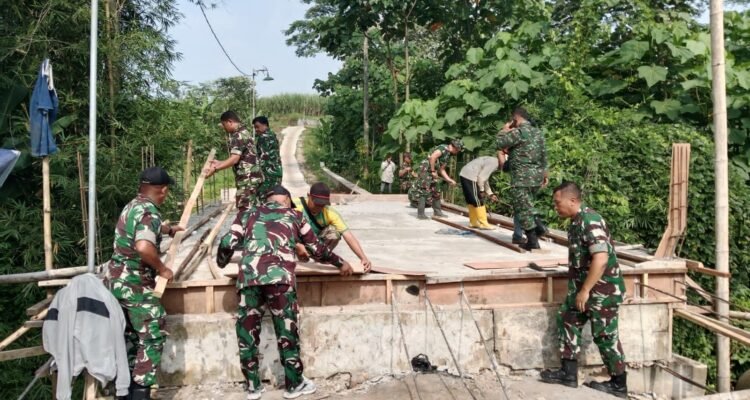Anggota Koramil Sukun Gotong Royong Rakit Rangka Pagar Jembatan Perintis Garuda