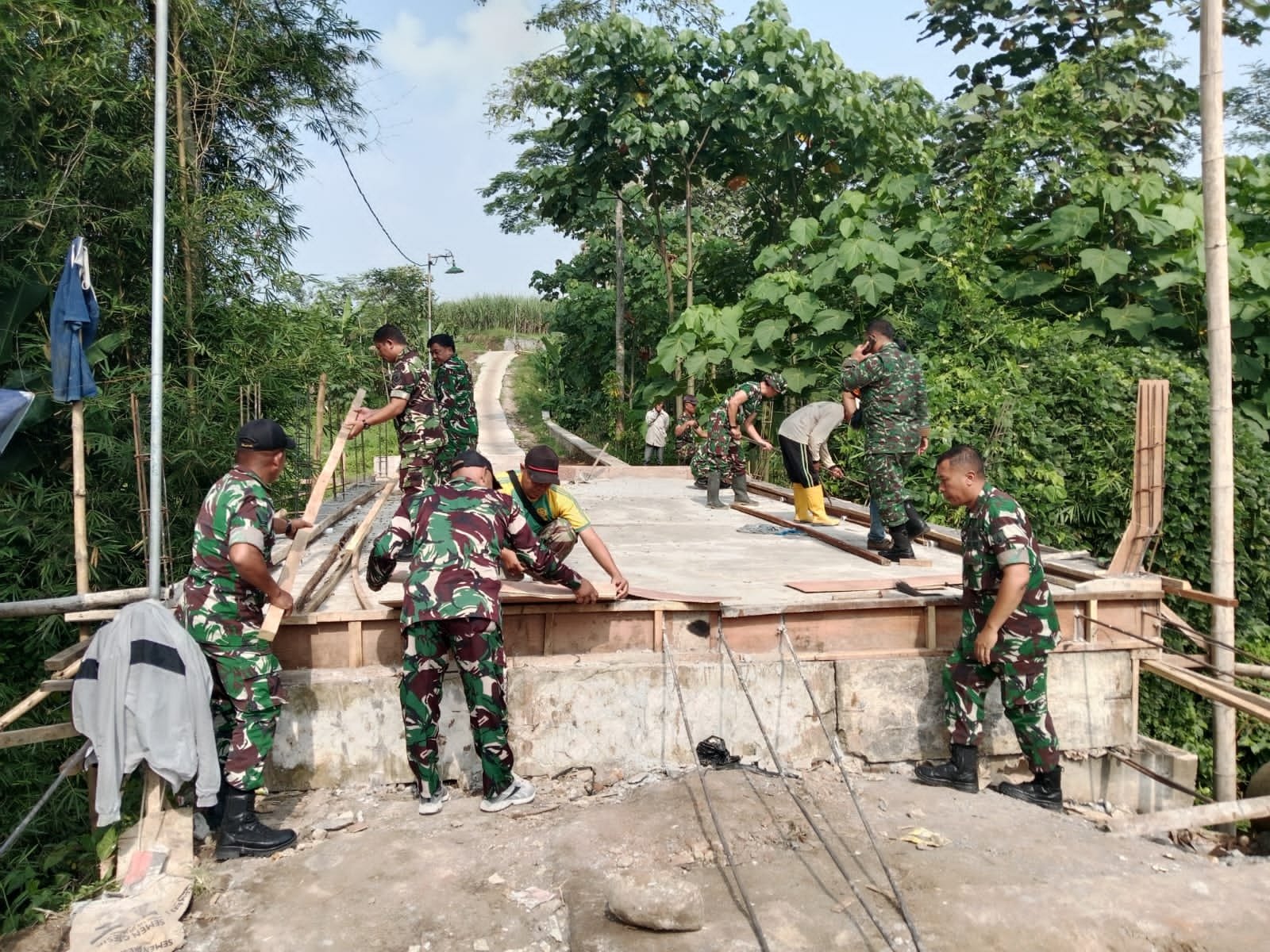 Anggota Koramil Sukun Gotong Royong Rakit Rangka Pagar Jembatan Perintis Garuda